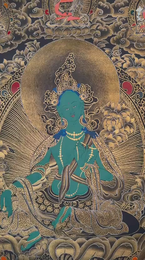 Black and Gold Green Tara thangka featuring the  Buddhist goddess seated on a lotus throne surrounded by golden floral motifs and celestial figures
