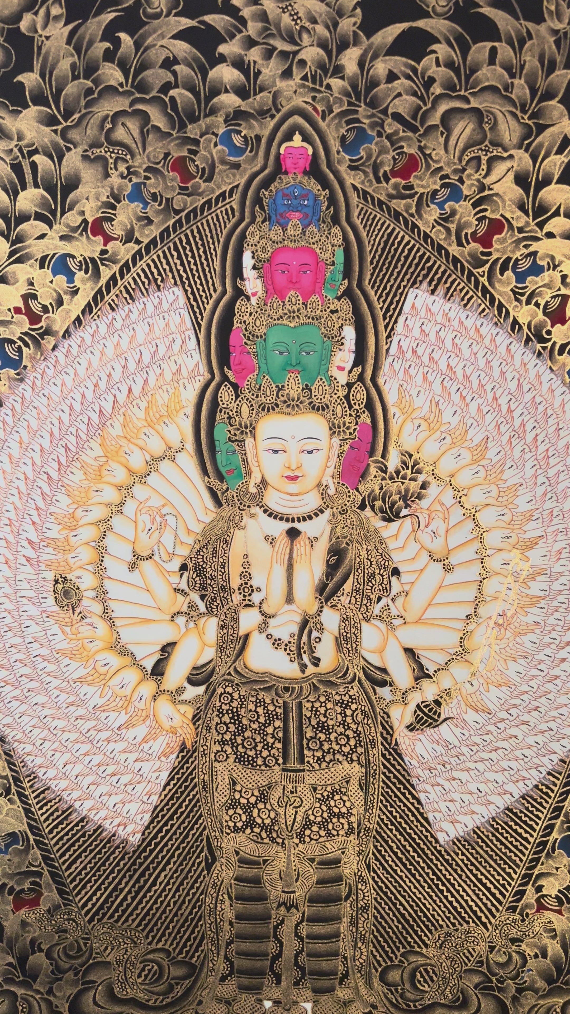 Hand-painted Thousand-Armed Avalokiteshvara thangka in gold on black background showing eleven-faced Chenrezig with multiple arms standing on lotus pedestal.