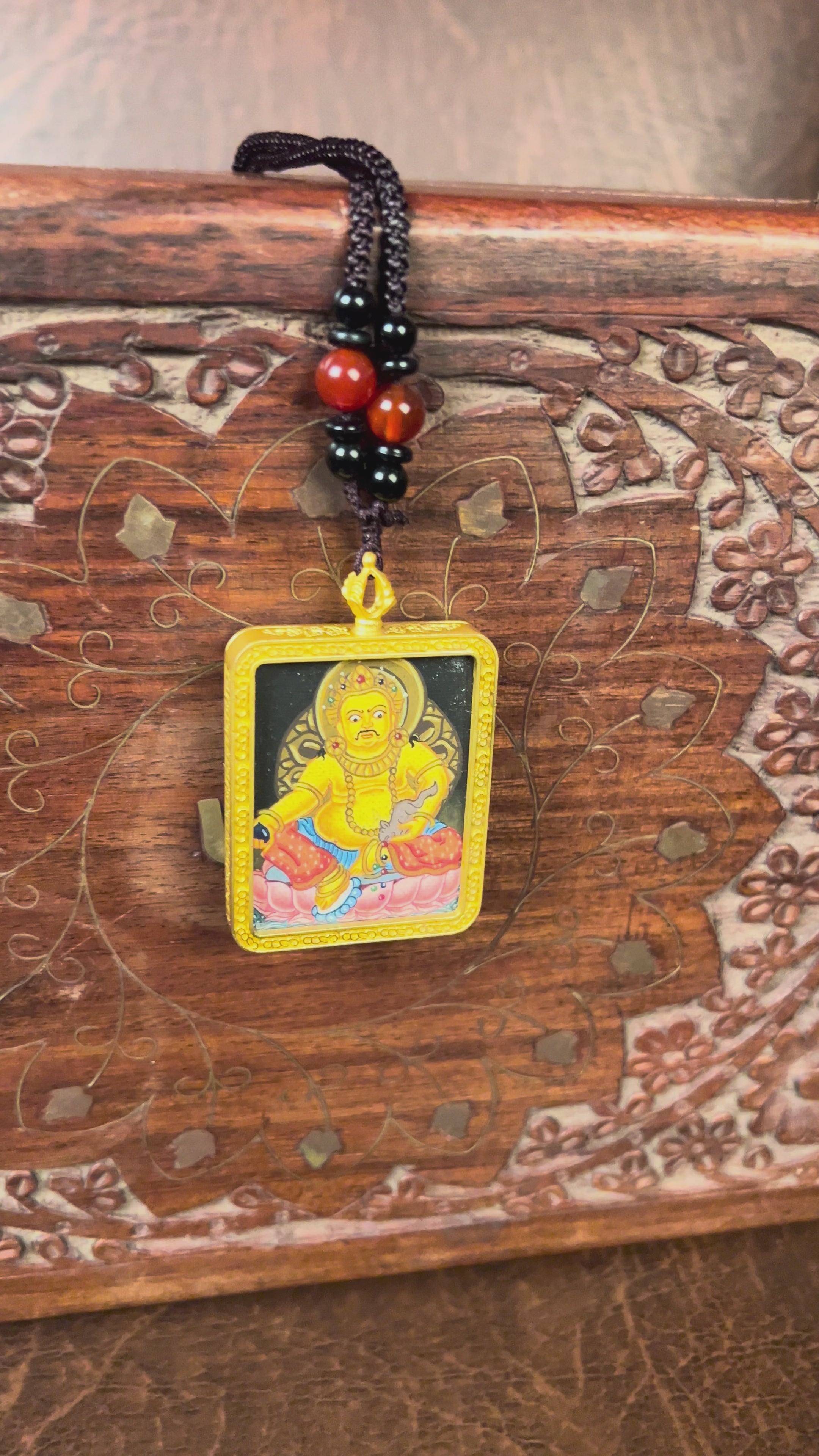 Hand-painted Yellow Zambala miniature Thangka pendant in gold-accented copper Ghau locket with black beaded cord.